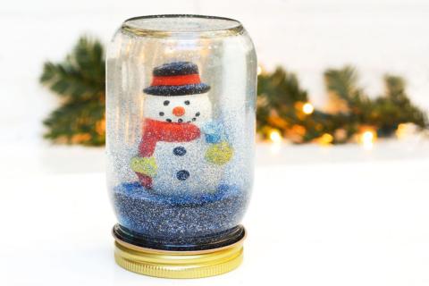 Mason jar snow globe with snowman inside.